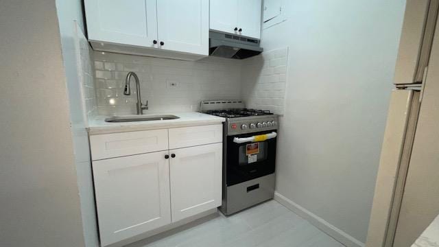 83-60 118th St Unit 3C, Kew Gardens, NY 11415 - kitchen featuring under cabinet range hood, stainless steel gas range, a sink, backsplash, and white cabinetry