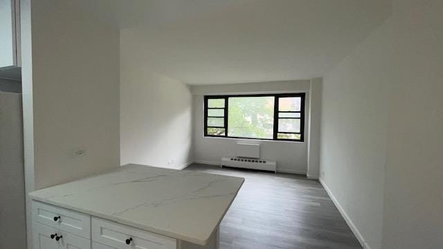 83-60 118th St Unit 3C, Kew Gardens, NY 11415 - empty room with a baseboard heating unit, wood finished floors, and baseboards
