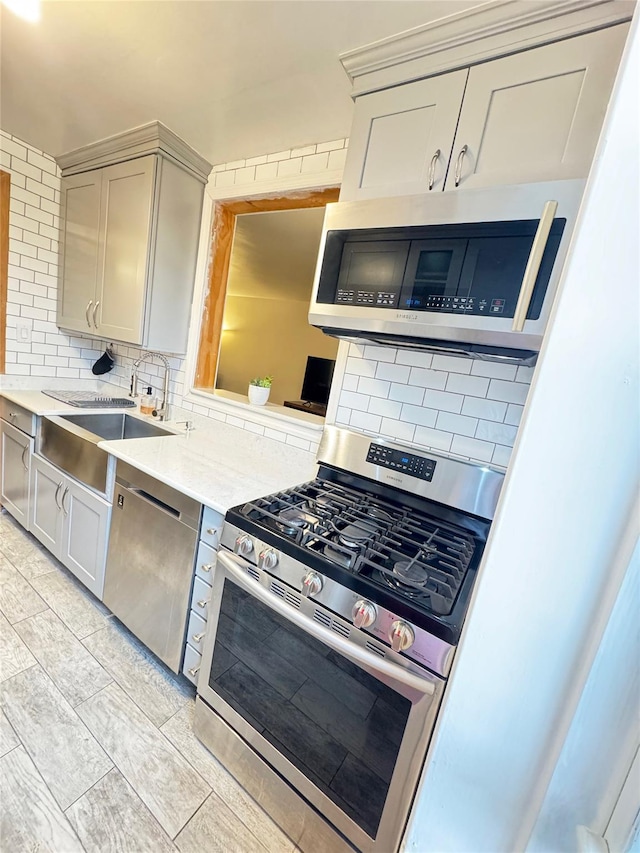 1475 Thieriot Ave Unit 6E, Bronx, NY 10460 - kitchen featuring stainless steel appliances, backsplash, light countertops, a sink, and gray cabinets