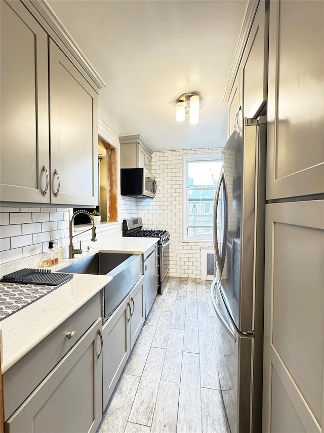 1475 Thieriot Ave Unit 6E, Bronx, NY 10460 - kitchen featuring appliances with stainless steel finishes, gray cabinets, a sink, light wood-type flooring, and tasteful backsplash