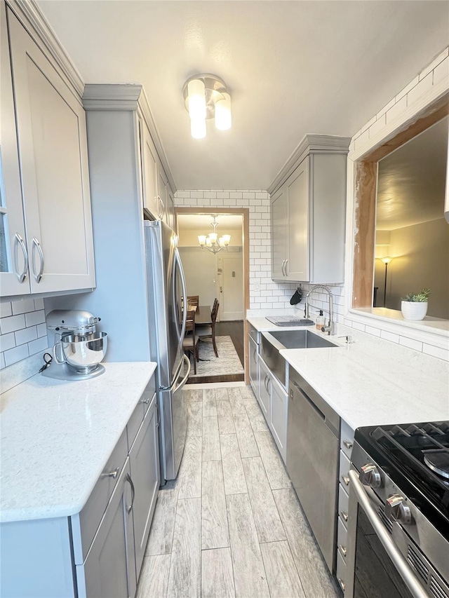 1475 Thieriot Ave Unit 6E, Bronx, NY 10460 - kitchen featuring gray cabinetry, appliances with stainless steel finishes, a sink, a chandelier, and backsplash