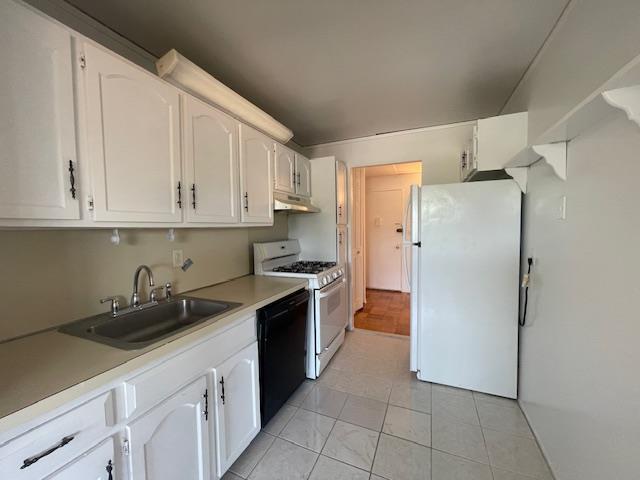 100 Clinton Ave Unit 4T, Mineola, NY 11501 - kitchen featuring white appliances, a sink, white cabinets, and under cabinet range hood