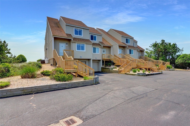4 Waters Edge Unit 4, Shirley, NY 11967 - view of front of house featuring stairs, a garage, a residential view, driveway, and a shingled roof