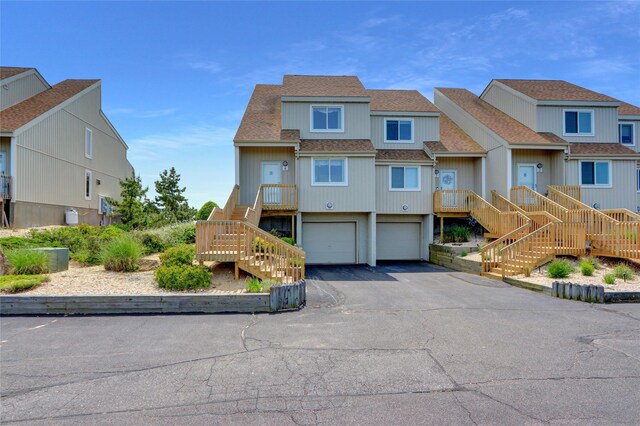 4 Waters Edge Unit 4, Shirley, NY 11967 - view of front facade with stairway, driveway, an attached garage, a shingled roof, and a residential view