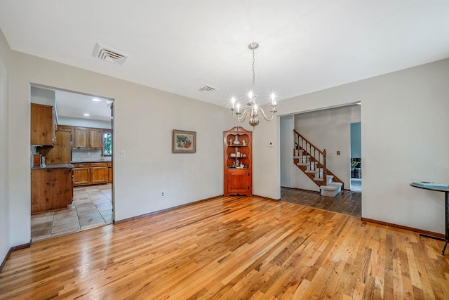 7 Sandpiper Ct, Shoreham, NY 11786 - unfurnished dining area featuring light wood-type flooring, a chandelier, stairs, and baseboards