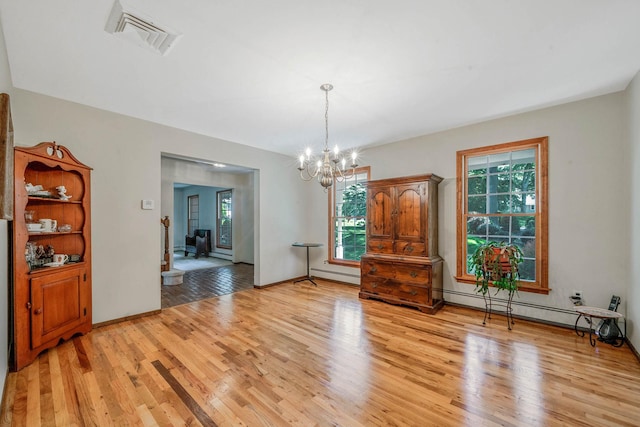 7 Sandpiper Ct, Shoreham, NY 11786 - unfurnished dining area with light wood-type flooring, a baseboard radiator, a chandelier, and a baseboard heating unit