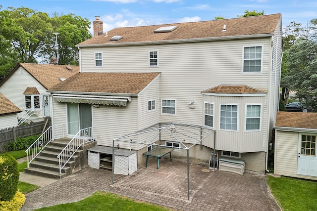 1448 Dewey Ave, North Bellmore, NY 11710 - rear view of property with a patio, roof with shingles, and a chimney