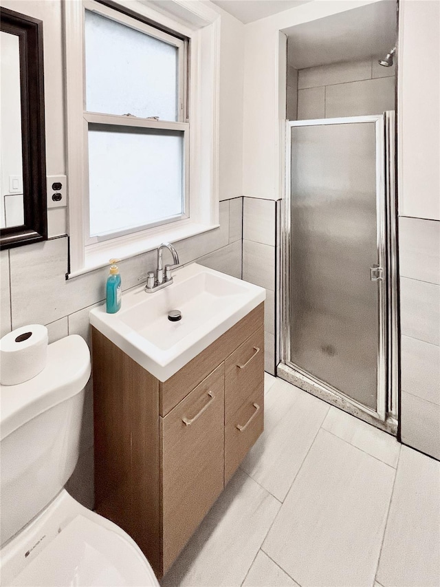 320 E 235th St, Bronx, NY 10470 - full bathroom featuring tile walls, vanity, toilet, and a stall shower