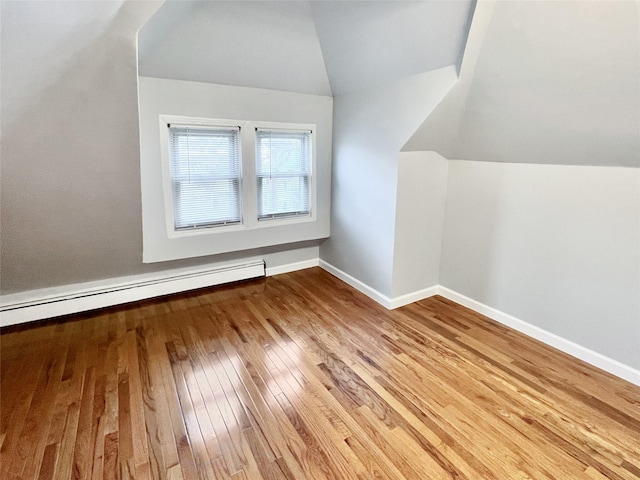 320 E 235th St, Bronx, NY 10470 - bonus room with wood-type flooring, vaulted ceiling, baseboards, and a baseboard radiator