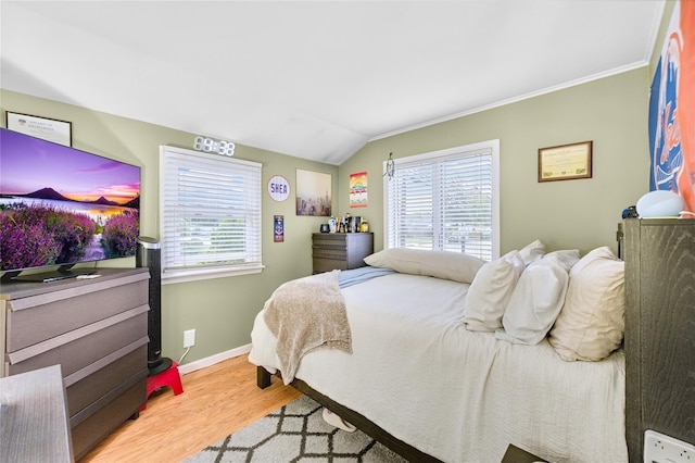 56 15th Ave, West Babylon, NY 11704 - bedroom featuring multiple windows, wood finished floors, baseboards, vaulted ceiling, and crown molding