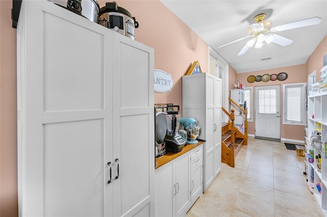 56 15th Ave, West Babylon, NY 11704 - kitchen with a ceiling fan, light tile patterned flooring, white cabinets, and baseboards