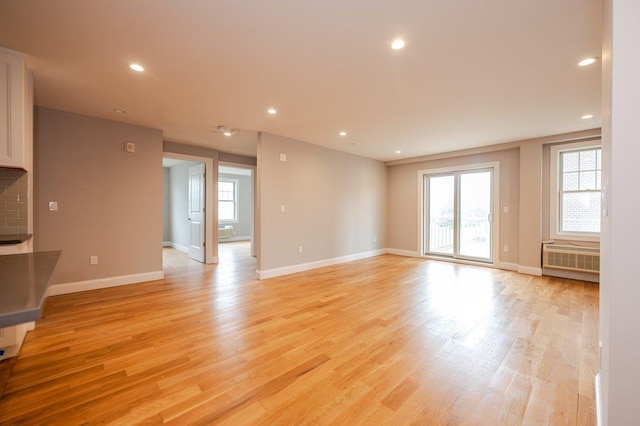 661 W Broadway Unit 204, Long Beach, NY 11561 - unfurnished living room with radiator heating unit, plenty of natural light, light wood-type flooring, baseboards, and recessed lighting