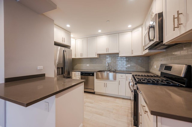 661 W Broadway Unit 204, Long Beach, NY 11561 - kitchen with stainless steel appliances, a sink, dark countertops, white cabinetry, and recessed lighting