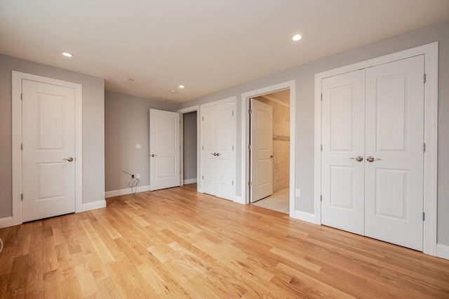 661 W Broadway Unit 204, Long Beach, NY 11561 - unfurnished bedroom with light wood-style floors, recessed lighting, baseboards, and connected bathroom