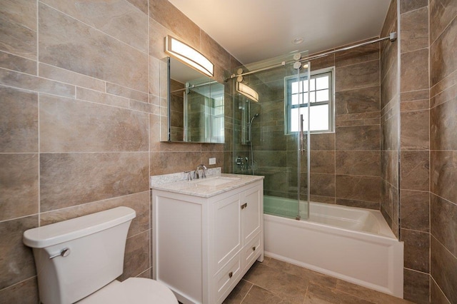 661 W Broadway Unit 204, Long Beach, NY 11561 - full bathroom featuring tile walls, vanity, toilet, and bath / shower combo with glass door