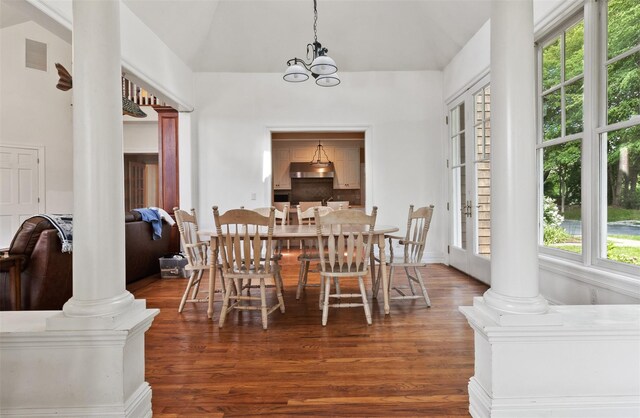 61 Carolyn Pl, Chappaqua, NY 10514 - dining area featuring ornate columns, wood finished floors, a chandelier, and high vaulted ceiling