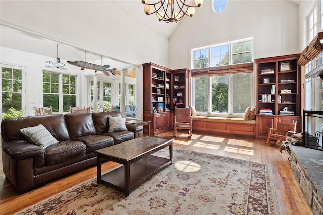61 Carolyn Pl, Chappaqua, NY 10514 - living room featuring high vaulted ceiling, hardwood / wood-style flooring, plenty of natural light, and a chandelier
