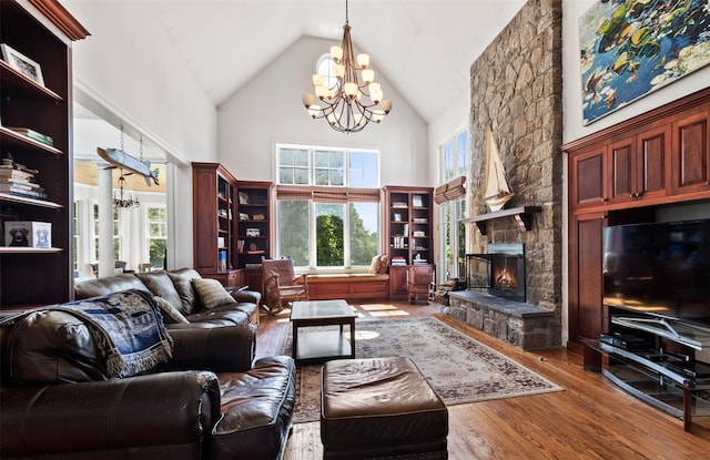 61 Carolyn Pl, Chappaqua, NY 10514 - living room featuring a chandelier, high vaulted ceiling, wood finished floors, and a stone fireplace