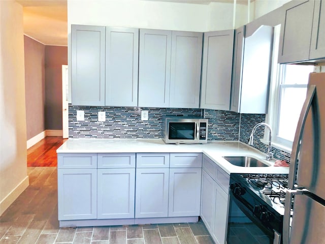 1528 Mayflower Ave, Bronx, NY 10461 - kitchen featuring appliances with stainless steel finishes, a sink, baseboards, light countertops, and decorative backsplash