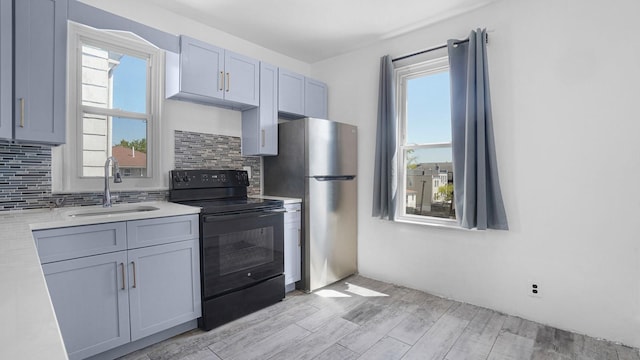 1528 Mayflower Ave, Bronx, NY 10461 - kitchen with black / electric stove, freestanding refrigerator, a sink, light countertops, and light wood-style floors