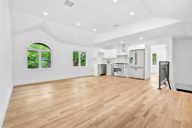 76-17 162nd St, Fresh Meadows, NY 11366 - unfurnished living room featuring healthy amount of natural light, recessed lighting, light wood-type flooring, lofted ceiling, and baseboards