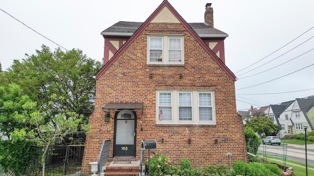 165 Page Rd, Valley Stream, NY 11581 - english style home featuring brick siding, a chimney, and roof with shingles