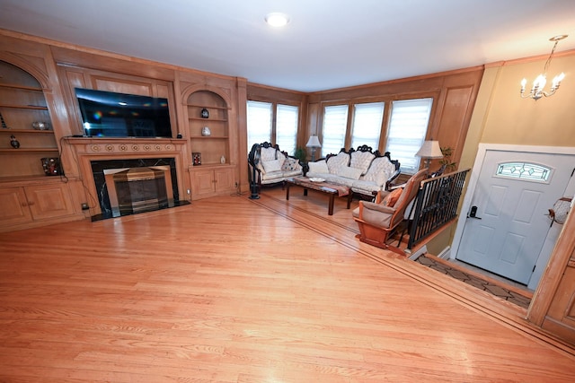 165 Page Rd, Valley Stream, NY 11581 - living room featuring light wood-type flooring, a chandelier, and a fireplace