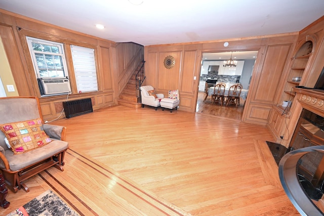 165 Page Rd, Valley Stream, NY 11581 - living room featuring stairs, light wood-style flooring, radiator heating unit, cooling unit, and a chandelier