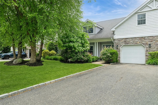 124 Pond View Dr Unit 317, Port Washington, NY 11050 - view of front of house with a front lawn, driveway, stone siding, roof with shingles, and a garage