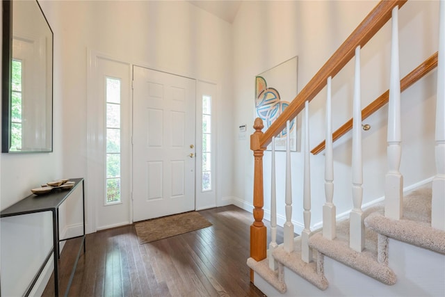 124 Pond View Dr Unit 317, Port Washington, NY 11050 - entryway featuring dark wood-style floors, stairway, a towering ceiling, and baseboards