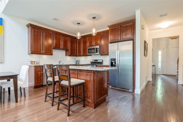 124 Pond View Dr Unit 317, Port Washington, NY 11050 - kitchen with stainless steel appliances, hardwood / wood-style floors, a kitchen island, and baseboards