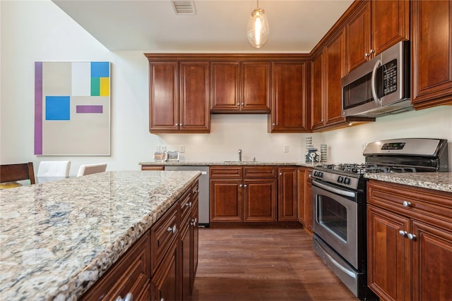 124 Pond View Dr Unit 317, Port Washington, NY 11050 - kitchen with appliances with stainless steel finishes, dark wood-style floors, a sink, light stone counters, and hanging light fixtures