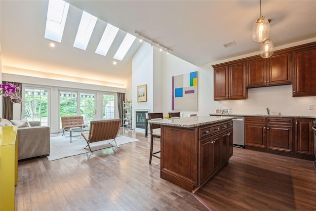 124 Pond View Dr Unit 317, Port Washington, NY 11050 - kitchen featuring open floor plan, track lighting, a skylight, stainless steel dishwasher, and a kitchen bar