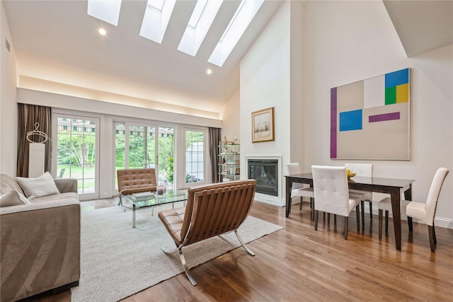 124 Pond View Dr Unit 317, Port Washington, NY 11050 - living area featuring high vaulted ceiling, a skylight, a glass covered fireplace, wood finished floors, and recessed lighting