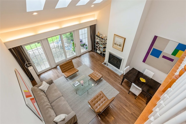 124 Pond View Dr Unit 317, Port Washington, NY 11050 - living area with wood finished floors, plenty of natural light, a glass covered fireplace, a skylight, and a towering ceiling