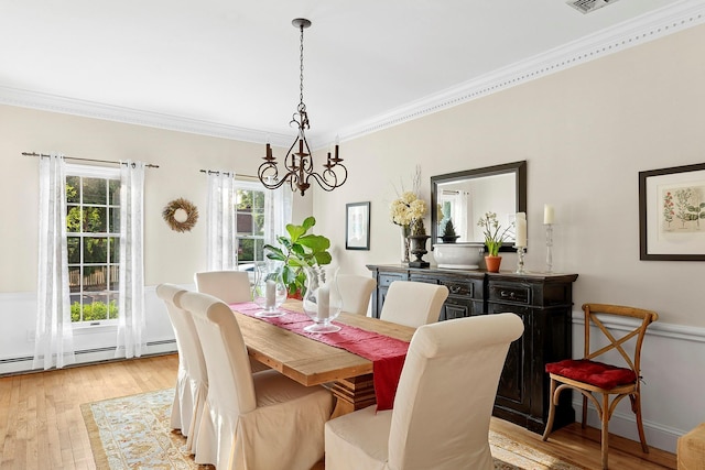38 Maple Ave, Northport, NY 11768 - dining area featuring a chandelier, ornamental molding, light wood-style flooring, and a baseboard heating unit