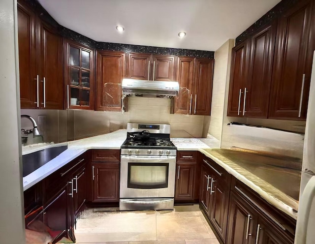 138-70 Elder Ave Unit 3C, Flushing, NY 11355 - kitchen featuring stainless steel gas range, ventilation hood, a sink, light countertops, and glass insert cabinets