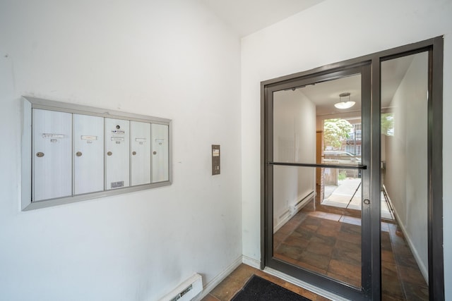 17524 89th Ave Unit C, Jamaica, NY 11432 - doorway to outside featuring mail area, baseboards, and stone finish flooring