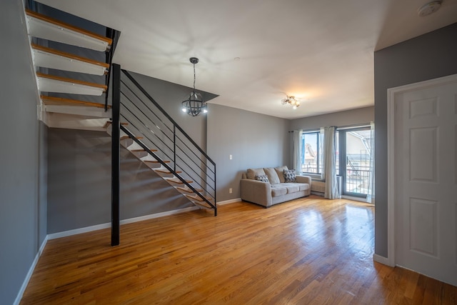 17524 89th Ave Unit C, Jamaica, NY 11432 - living room with stairs, wood finished floors, baseboards, and a chandelier