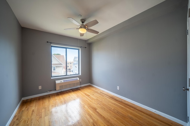 17524 89th Ave Unit C, Jamaica, NY 11432 - spare room with a wall mounted AC, ceiling fan, light wood-style flooring, and baseboards