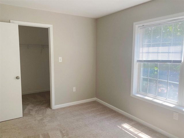 122 Oak Park Ter, Wappingers Falls, NY 12590 - unfurnished bedroom with a walk in closet, light carpet, a closet, and baseboards