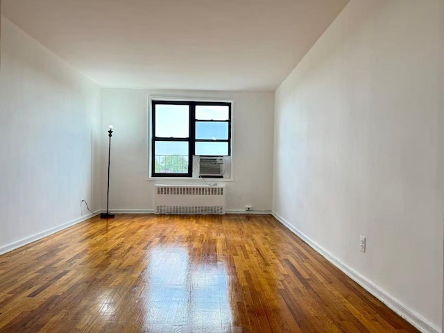 38-15 149th St Unit 6S, Flushing, NY 11354 - unfurnished room with radiator, wood finished floors, baseboards, and cooling unit