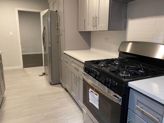 138-70 Elder Ave Unit 7H, Flushing, NY 11355 - kitchen featuring gas stove, freestanding refrigerator, gray cabinets, decorative backsplash, and light countertops