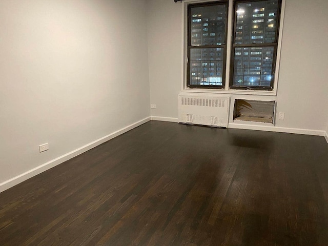 138-70 Elder Ave Unit 7H, Flushing, NY 11355 - unfurnished room featuring radiator, dark wood-type flooring, and baseboards