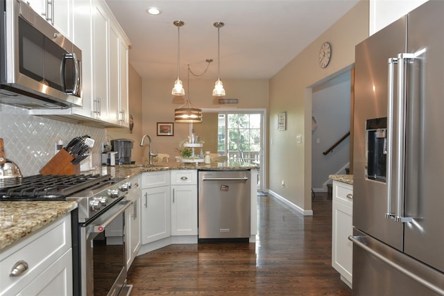 2 Hidden Creek Blvd, Monroe, NY 10950 - kitchen featuring appliances with stainless steel finishes, dark wood-type flooring, a sink, a peninsula, and decorative backsplash