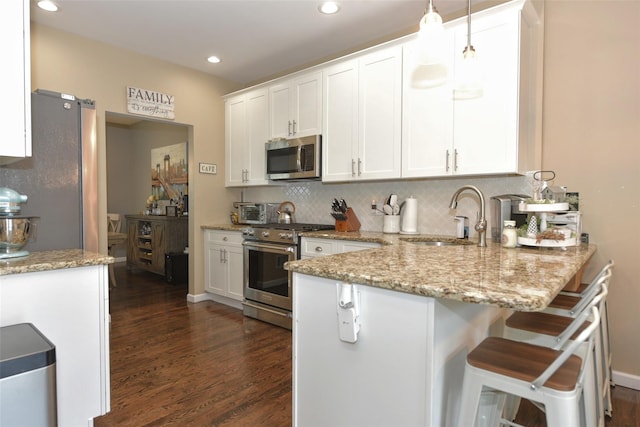 2 Hidden Creek Blvd, Monroe, NY 10950 - kitchen featuring stainless steel appliances, a sink, a peninsula, dark wood-style flooring, and backsplash