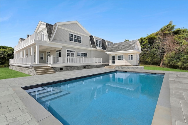 44 Club Ln, Remsenburg, NY 11960 - back of property with a gambrel roof, an outbuilding, an outdoor pool, a patio, and a balcony