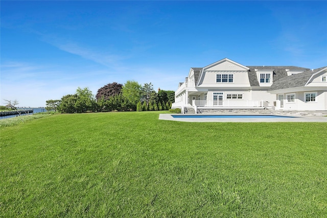 44 Club Ln, Remsenburg, NY 11960 - rear view of property featuring a gambrel roof, a yard, an outdoor pool, a water view, and a patio
