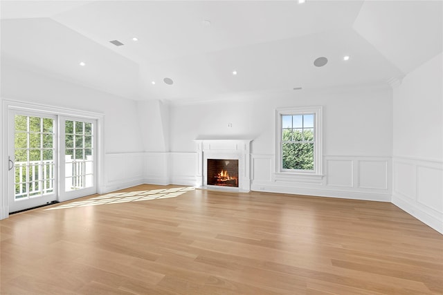 44 Club Ln, Remsenburg, NY 11960 - unfurnished living room featuring healthy amount of natural light, a decorative wall, a fireplace with flush hearth, a wainscoted wall, and light wood-type flooring