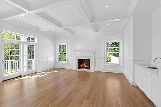 44 Club Ln, Remsenburg, NY 11960 - unfurnished living room featuring plenty of natural light, beamed ceiling, a high end fireplace, a sink, and light wood-type flooring
